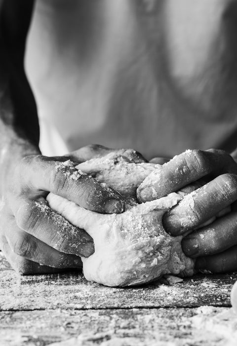 Mani che impastano il pane in bianco e nero